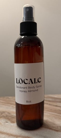 Brown spray bottle labeled 'Locale' on a wooden surface with a neutral background